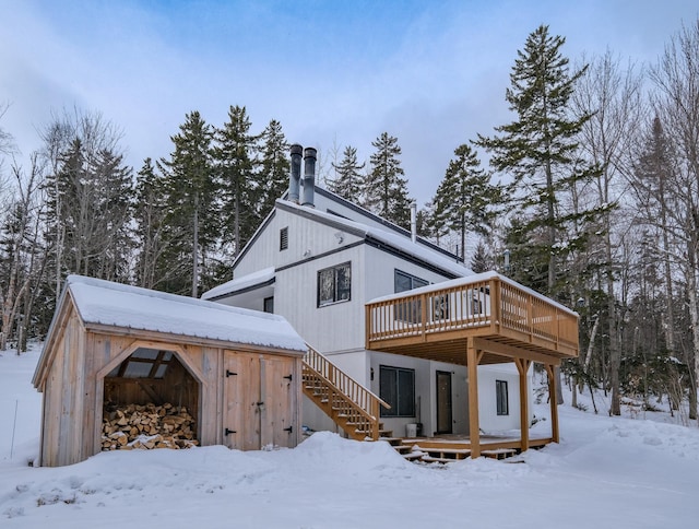 snow covered rear of property with a wooden deck