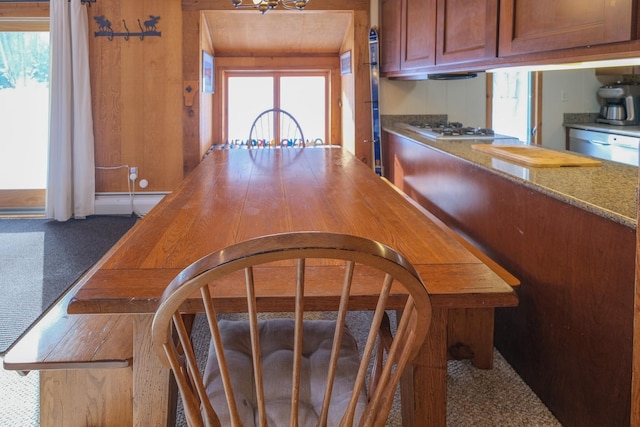 kitchen featuring stainless steel dishwasher, white gas cooktop, and light stone countertops