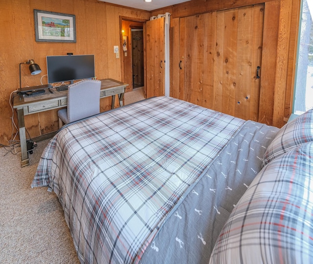 bedroom featuring light colored carpet and wooden walls