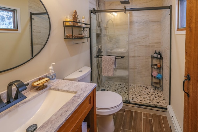 bathroom with vanity, toilet, an enclosed shower, and a baseboard radiator