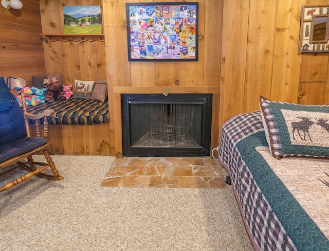 carpeted bedroom featuring wood walls