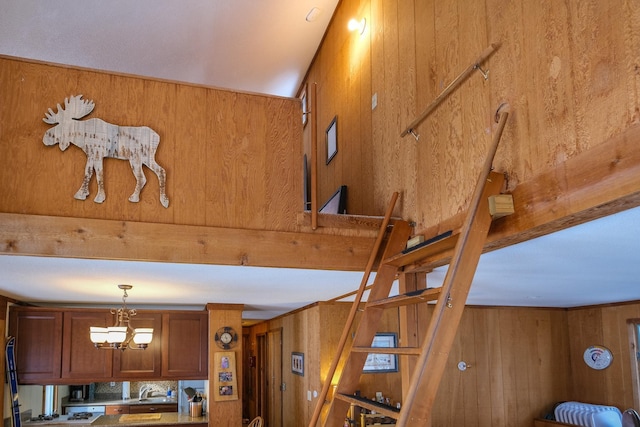 interior details featuring a notable chandelier, sink, and wood walls