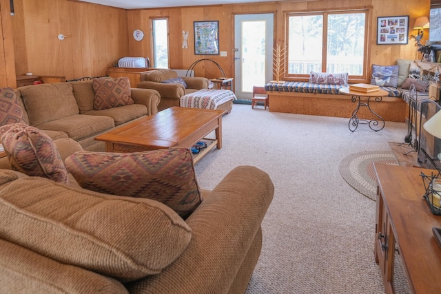 carpeted living room with wood walls