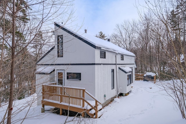 snow covered property with a wooden deck