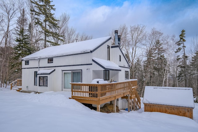 snow covered rear of property featuring a wooden deck