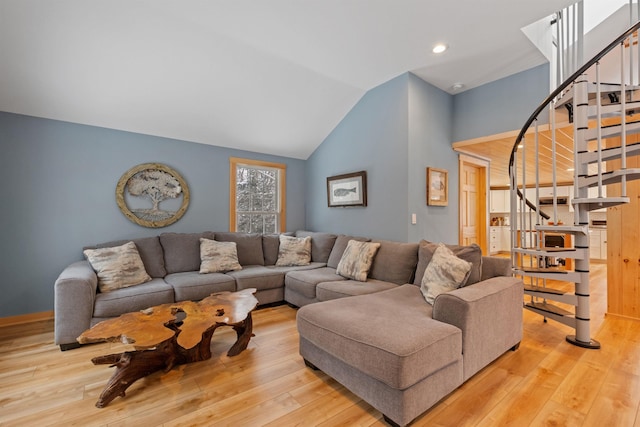 living room with hardwood / wood-style flooring, stairway, and vaulted ceiling