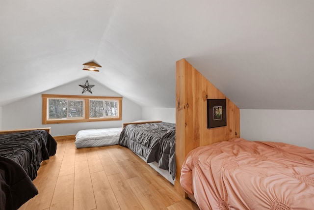 bedroom featuring light wood-style floors and vaulted ceiling