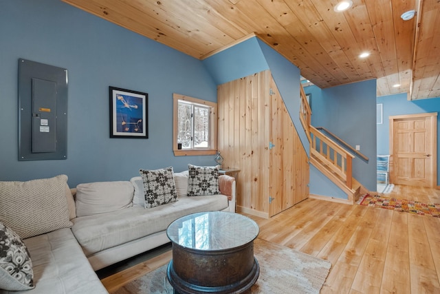 living area with wood-type flooring, stairway, wood ceiling, vaulted ceiling, and electric panel