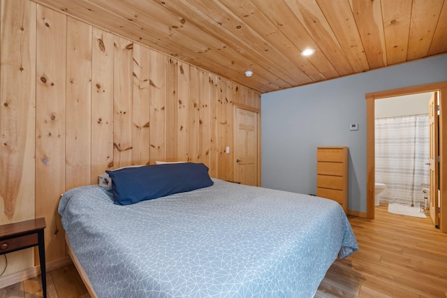 bedroom with baseboards, wood finished floors, wood ceiling, and wooden walls