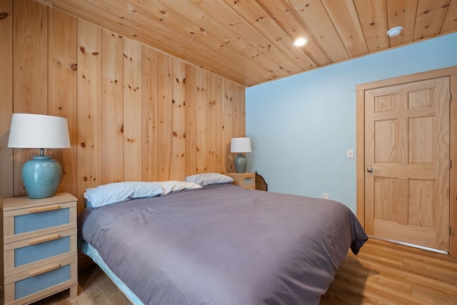 bedroom with wood finished floors, wood ceiling, and wooden walls