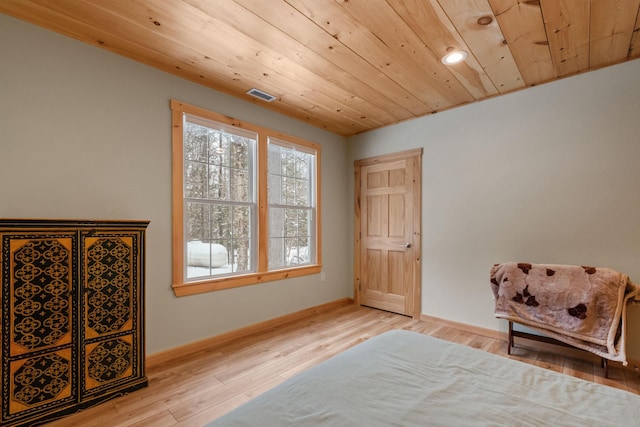 bedroom with wood ceiling, visible vents, baseboards, and wood finished floors