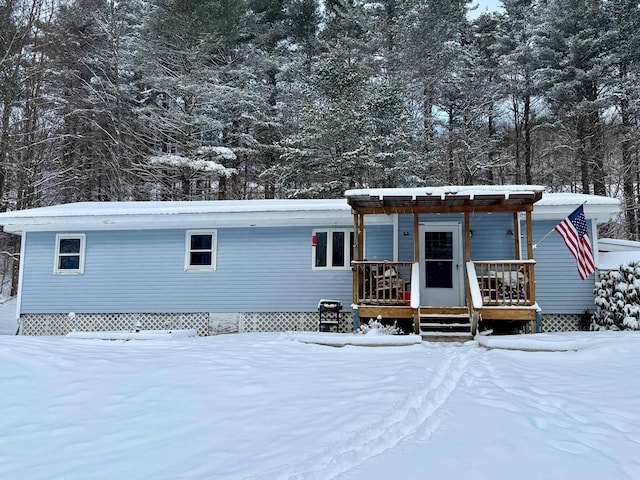 snow covered property with covered porch