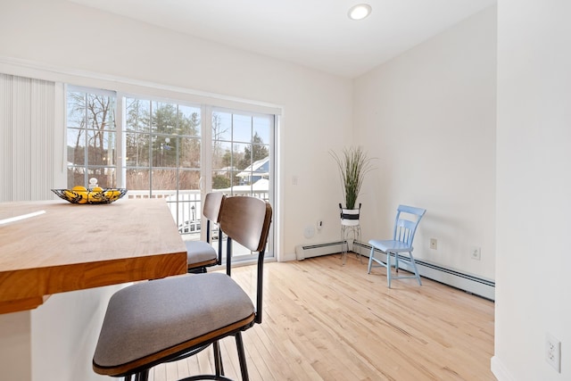 dining room with baseboard heating and light wood-type flooring