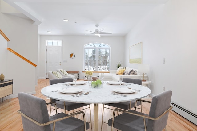 dining area with ceiling fan, baseboard heating, and light hardwood / wood-style flooring