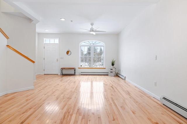 foyer with light wood-type flooring, baseboard heating, and ceiling fan