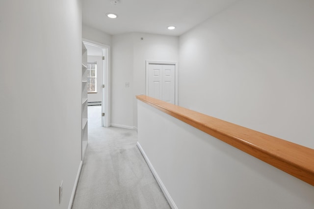 hall with light colored carpet and baseboard heating