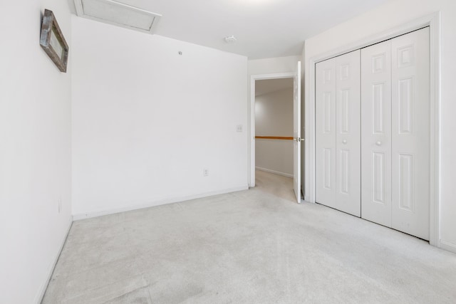 unfurnished bedroom featuring light carpet and a closet