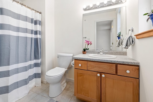 bathroom with toilet, vanity, and tile patterned floors