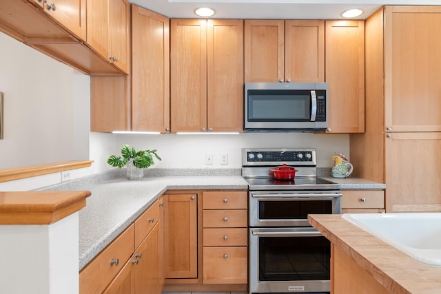 kitchen featuring light brown cabinetry and appliances with stainless steel finishes