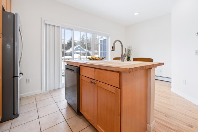 kitchen featuring stainless steel fridge, a baseboard radiator, a kitchen island with sink, dishwasher, and sink