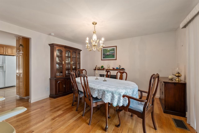 dining space featuring a notable chandelier and light hardwood / wood-style floors