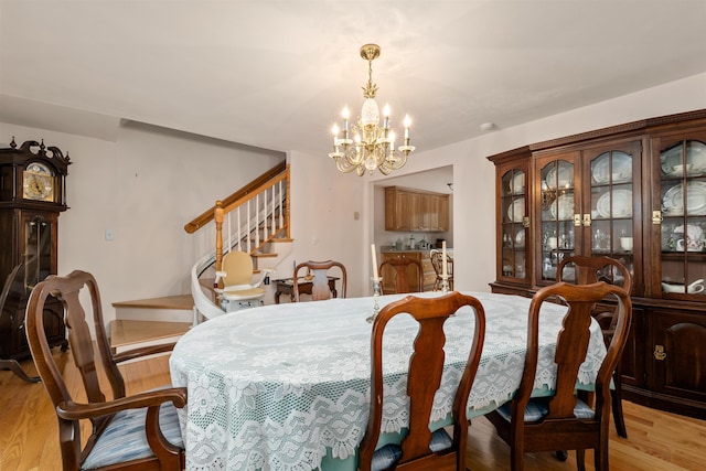 dining area featuring light hardwood / wood-style floors and a notable chandelier