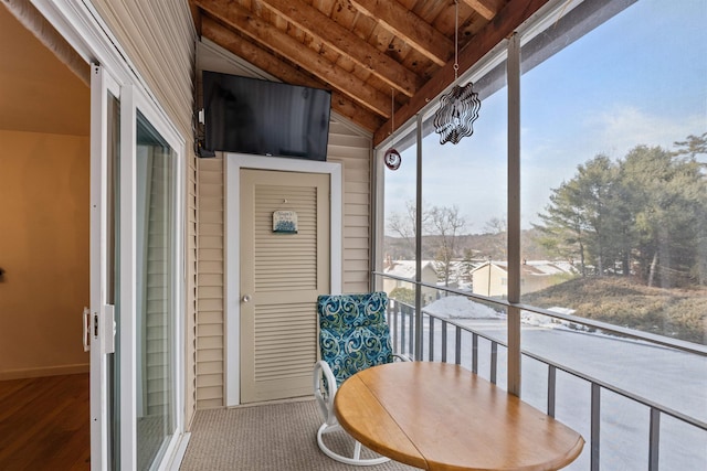 sunroom featuring a healthy amount of sunlight, wood ceiling, and vaulted ceiling