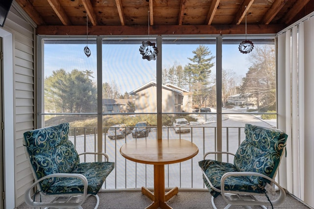 sunroom / solarium featuring lofted ceiling with beams and wooden ceiling