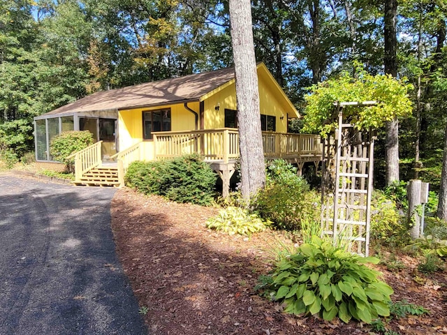 view of front of house with a wooden deck and a sunroom