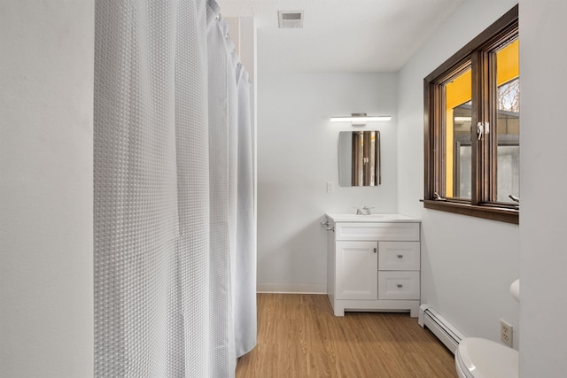 bathroom with a baseboard radiator, hardwood / wood-style floors, vanity, a shower with curtain, and toilet