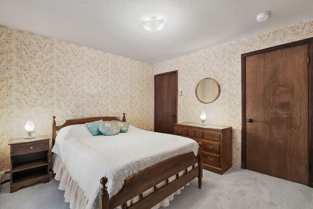 bedroom featuring light colored carpet and a textured ceiling