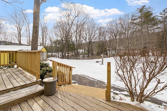 snow covered deck featuring a garage and an outdoor structure