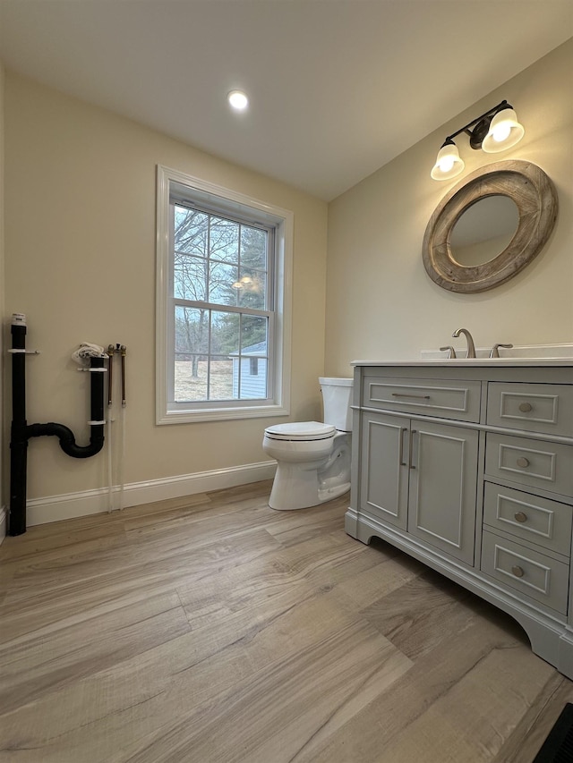 bathroom featuring toilet, vanity, and hardwood / wood-style flooring