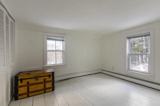 spare room with light wood-type flooring and a baseboard heating unit