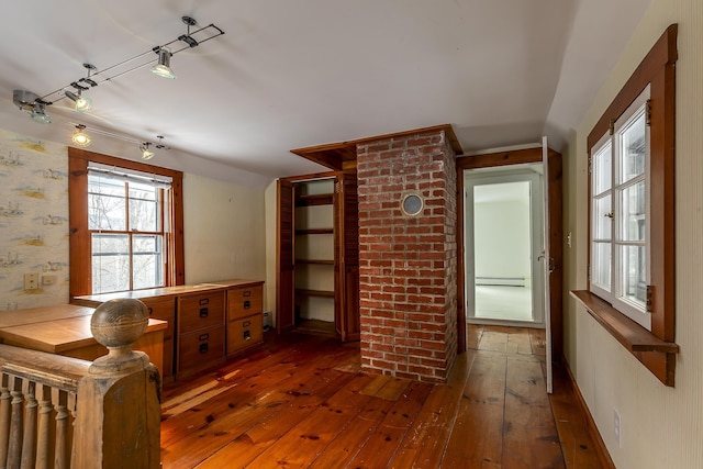 interior space with baseboard heating, dark hardwood / wood-style flooring, and rail lighting