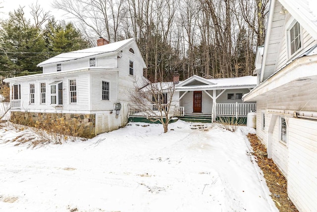 snow covered property featuring covered porch