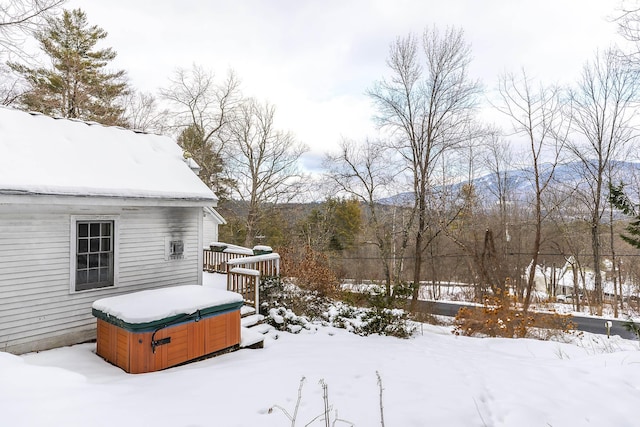 snowy yard featuring a hot tub and a wooden deck