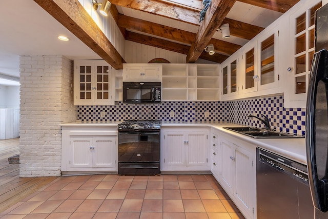 kitchen with black appliances, vaulted ceiling with beams, sink, white cabinetry, and light tile patterned floors