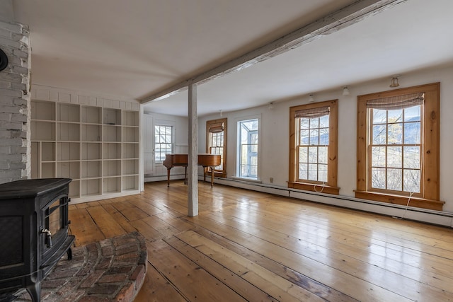 unfurnished living room with light wood-type flooring and a wood stove