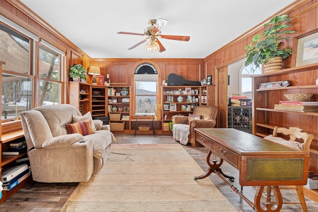 interior space featuring wood walls, plenty of natural light, crown molding, and ceiling fan