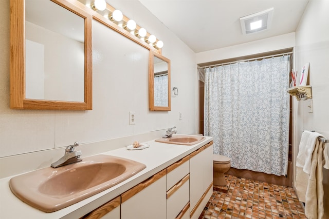 bathroom featuring toilet, vanity, and a shower with curtain