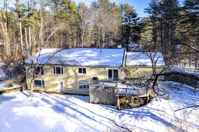 snow covered house featuring a wooden deck