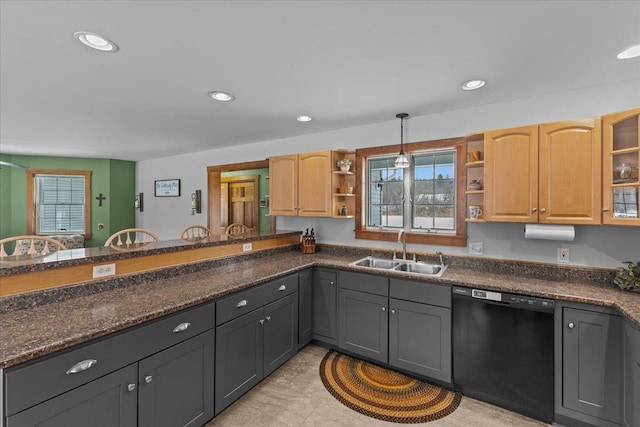 kitchen featuring light brown cabinets, dark stone countertops, dishwasher, hanging light fixtures, and sink