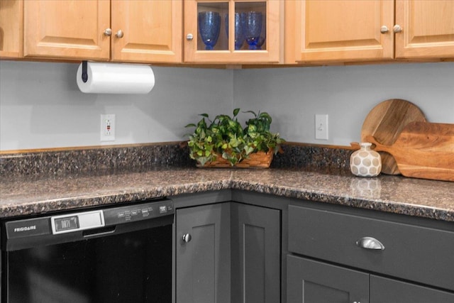 room details with dark stone countertops and black dishwasher