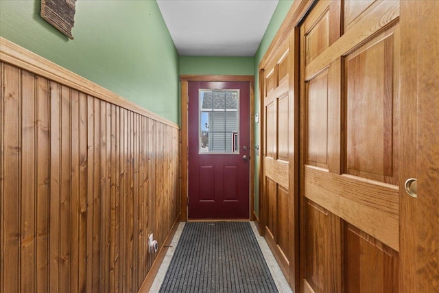 doorway to outside featuring wood walls