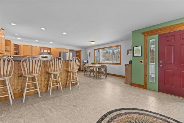 interior space with stainless steel fridge and a kitchen breakfast bar