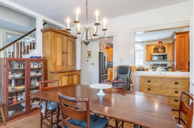 dining space featuring light wood-type flooring and a chandelier