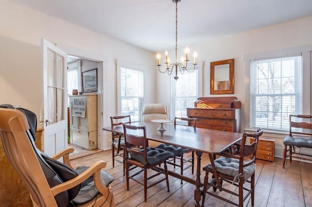 dining area with plenty of natural light, a chandelier, and light hardwood / wood-style flooring