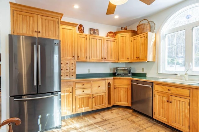 kitchen with ceiling fan, sink, appliances with stainless steel finishes, and light hardwood / wood-style floors