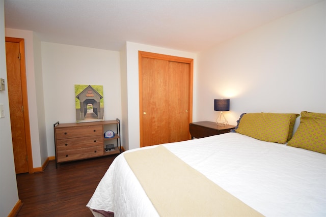 bedroom with dark wood-type flooring and a closet